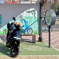 Source: Reuters. A man checks his mobile phone as he waits while recharging his Ola electric scooter at an electric vehicle charging station in New Delhi, India, 12 February, 2022.