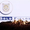 A small toy figure and gold imitation are seen in front of the Gold Fields logo in this illustration. Image credit: Reuters/Dado Ruvic/Illustration