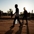 Source: Reuters. Young residents carry water home after filling up a bottle at a community filling station in the informal settlement of Kanana after individuals died from cholera in Hammanskraal, South Africa, 24 May, 2023.